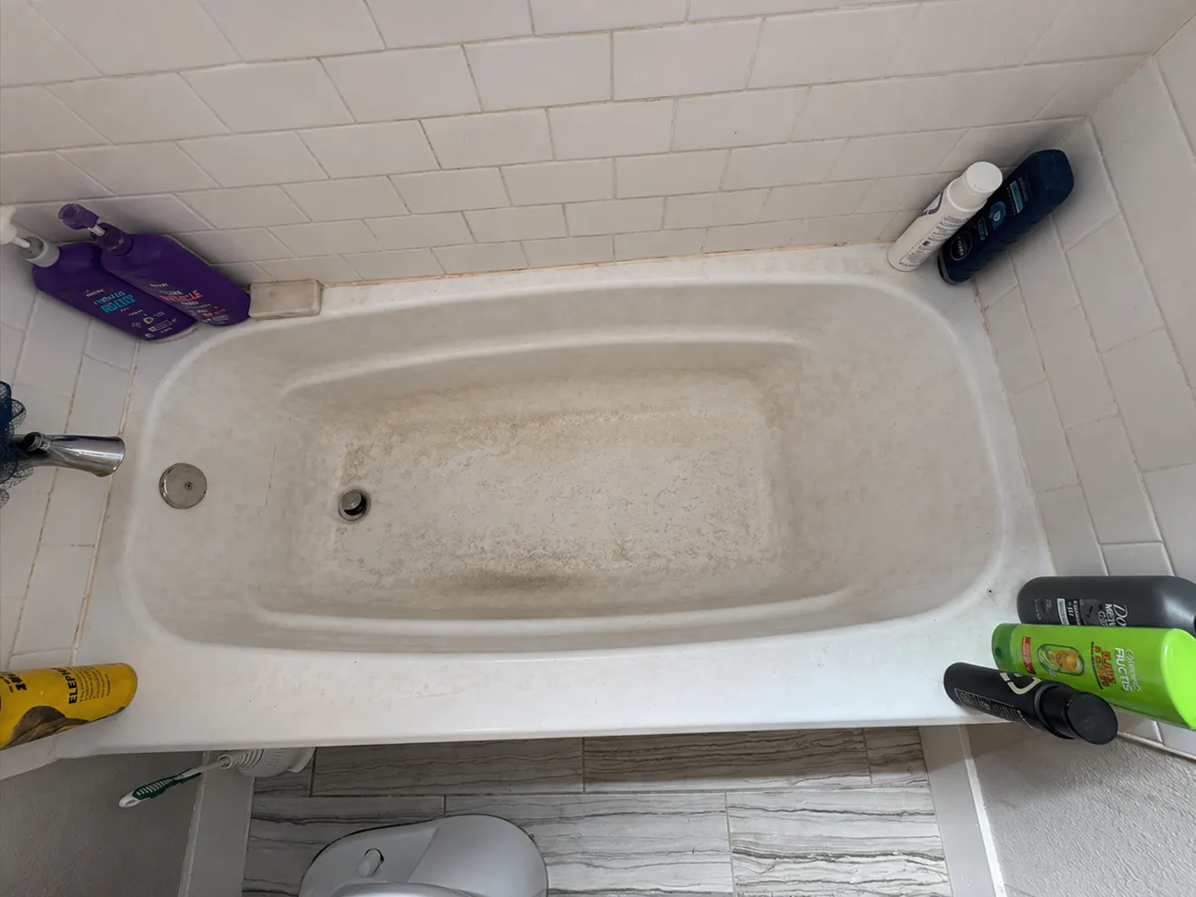 Dirty bathtub and tile surround before cleaning