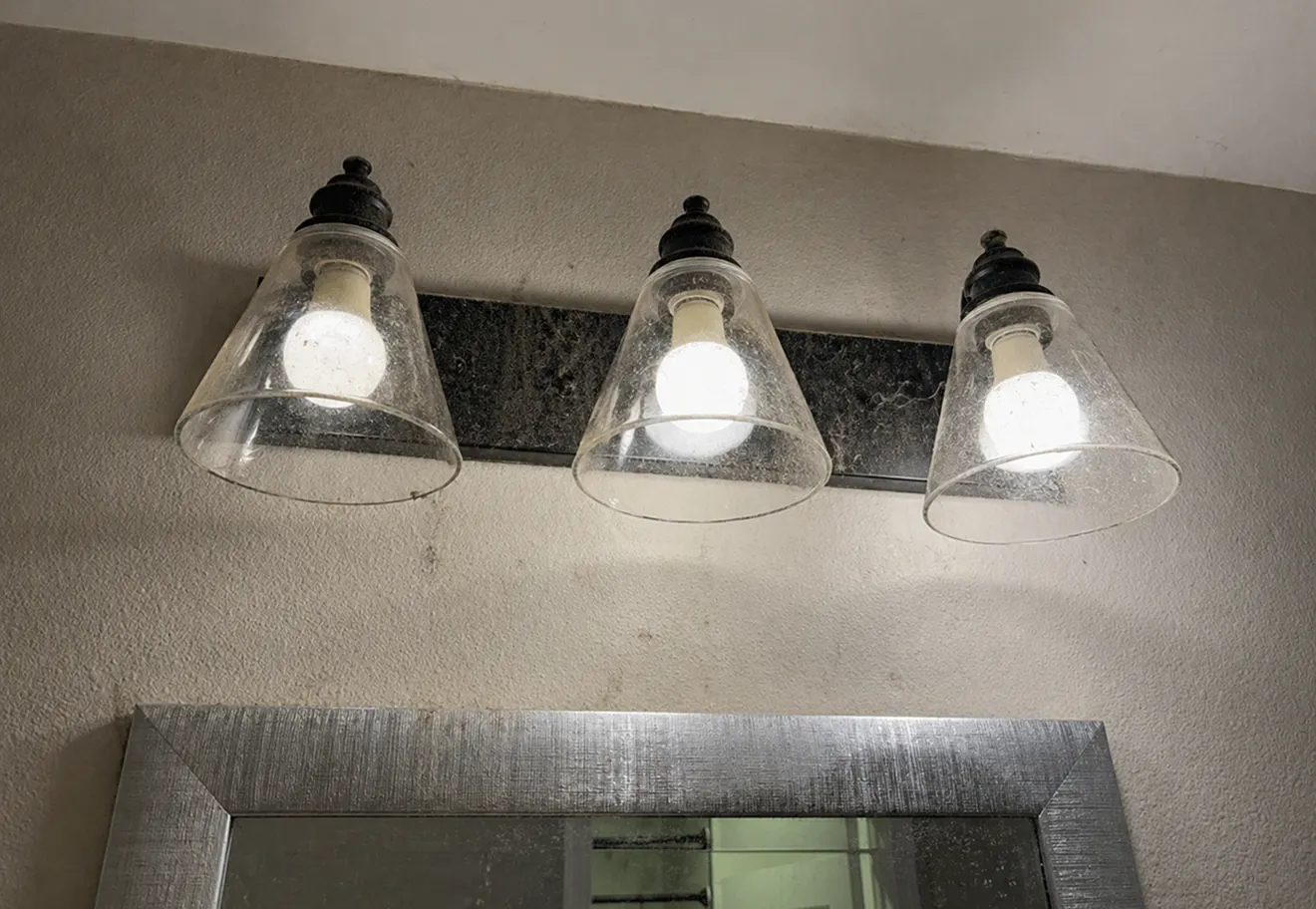 Dusty bathroom vanity lights before cleaning