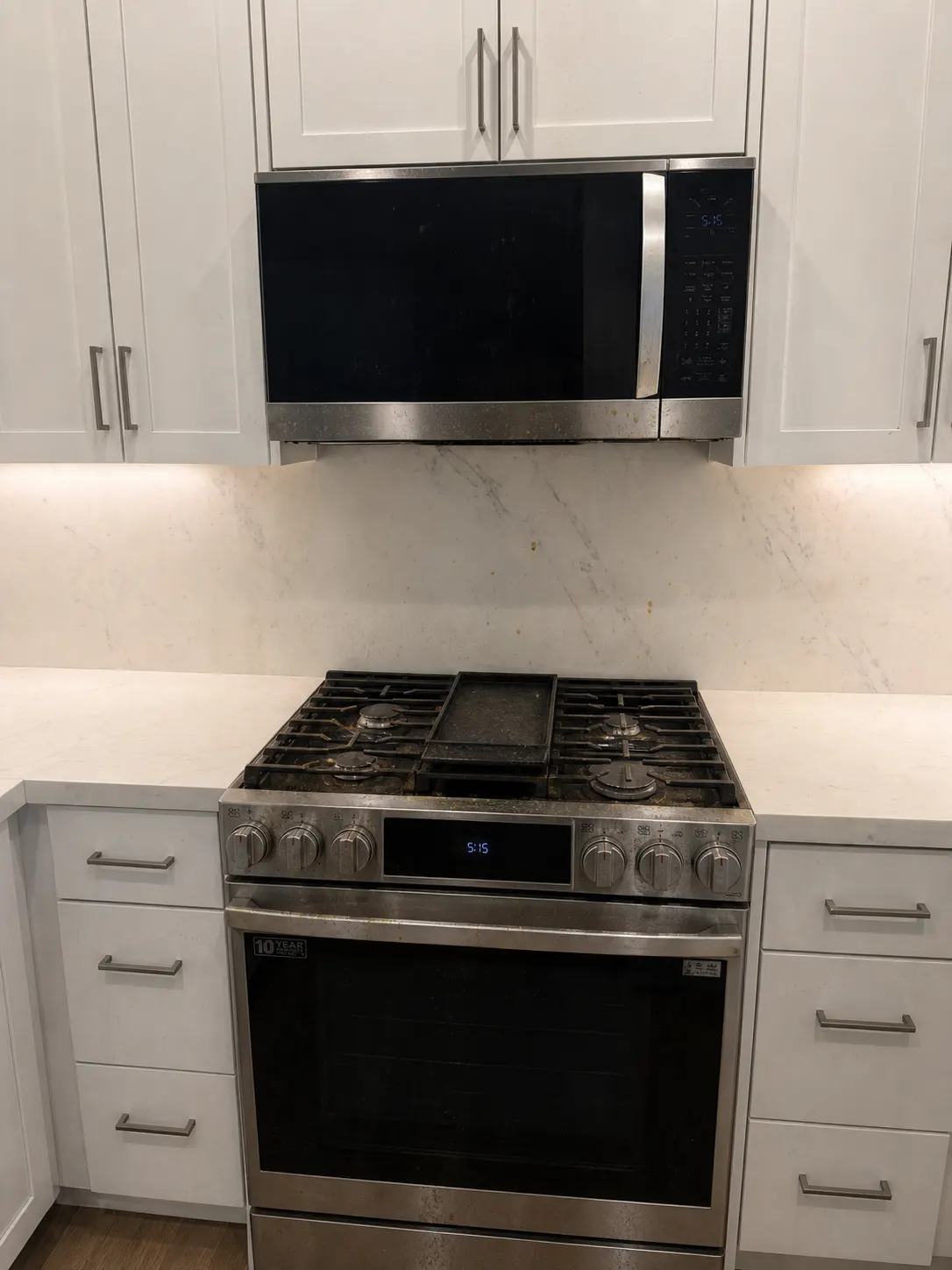 Dirty stovetop and microwave area before cleaning